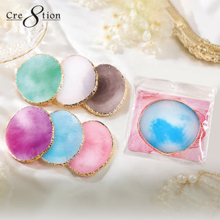Round gold rimmed Cre8tion palettes in mint, pink, white and magenta on cream silk with pearls.