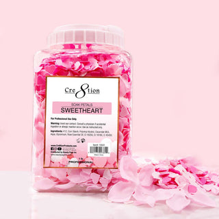 Jar of Cre8tion Sweetheart soak petals in pink and white on a pink set, loose petals spilled beside it.