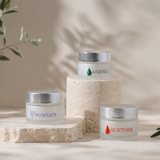 Three Cre8tion frosted glass jars with silver caps, labeled liquid, powder and acetone, on stone plinths.