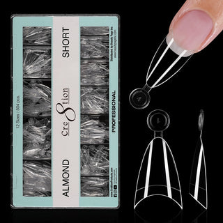 Open mint green box of clear Cre8tion Almond Short tips on black, one tip fitted to a fingertip.