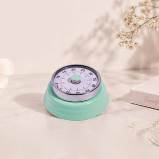 Mint green retro Cre8tion mechanical timer with a numbered dial, on a pale styled surface.
