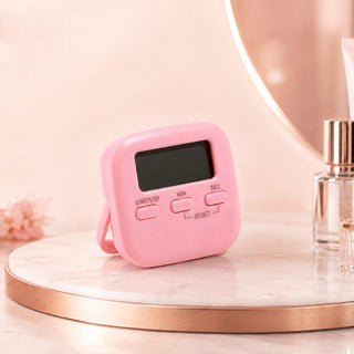 Pink Cre8tion digital salon timer with a square display, standing on a marble riser.